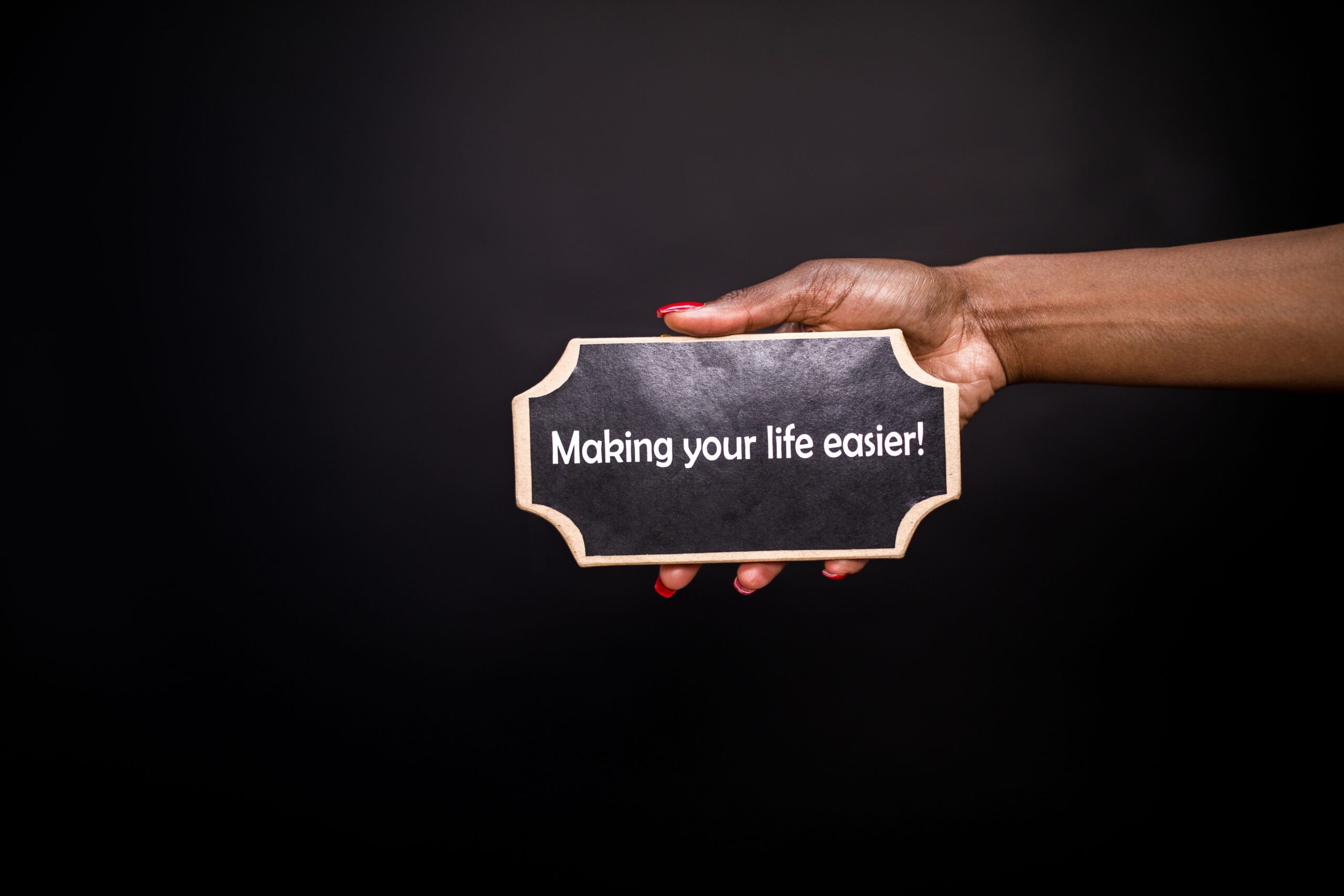 A hand holding a small chalkboard sign